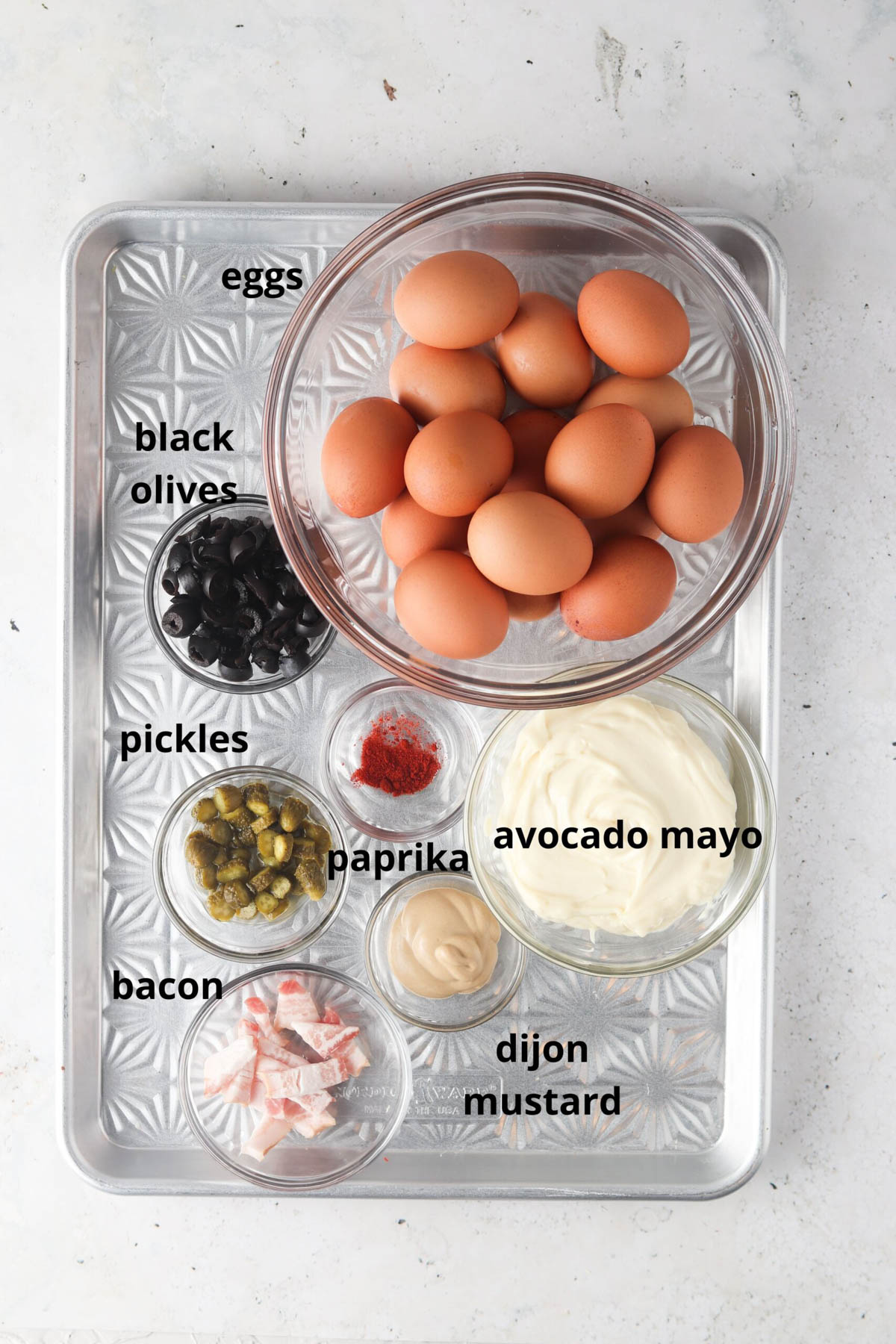 All ingredients laid out on a sheet pan in small glass bowls. 