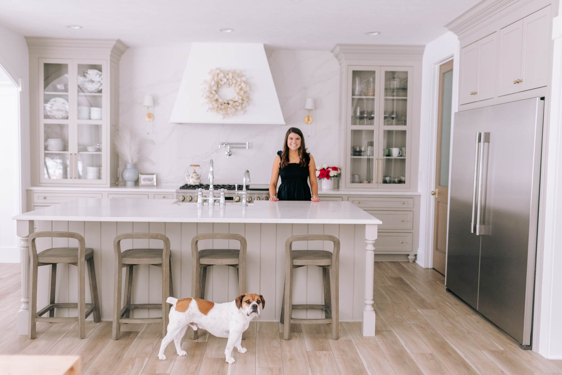 Allianna standing in a kitchen with a dog. 