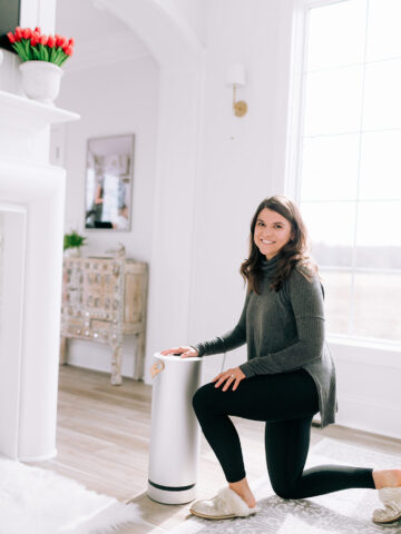 Allianna kneeling next to an air purifier