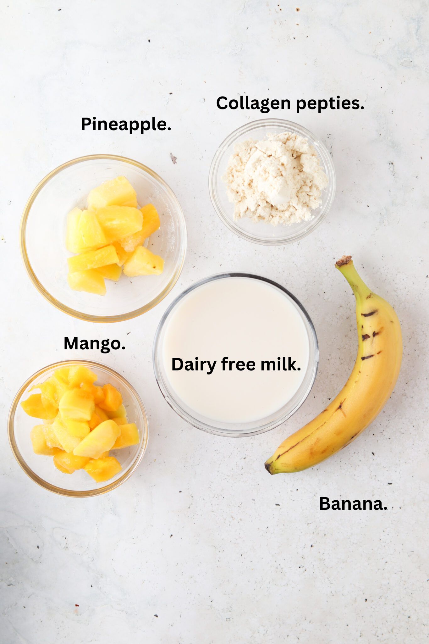 Smoothie ingredients laid out in bowls on the counter.