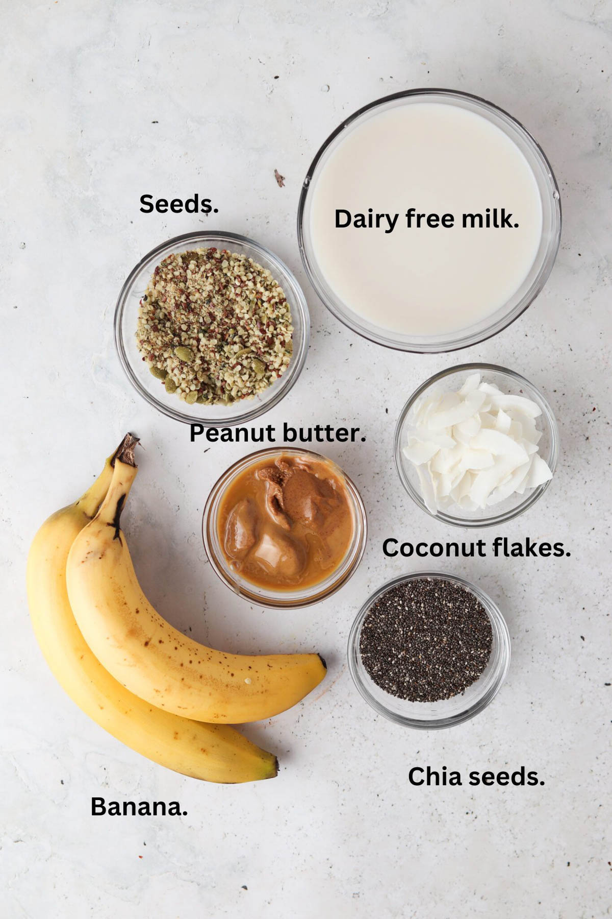 Chia pudding ingredients laid out in glass bowls on the counter top.