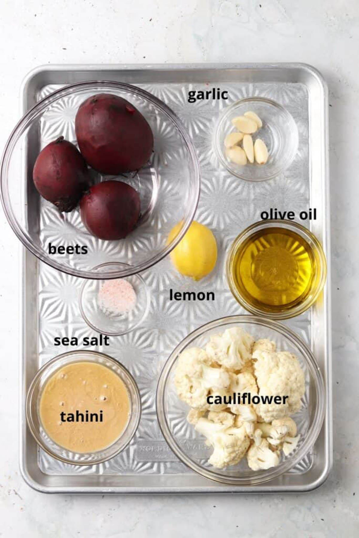 Beetroot dip ingredients in glass bowls on a silver tray. 