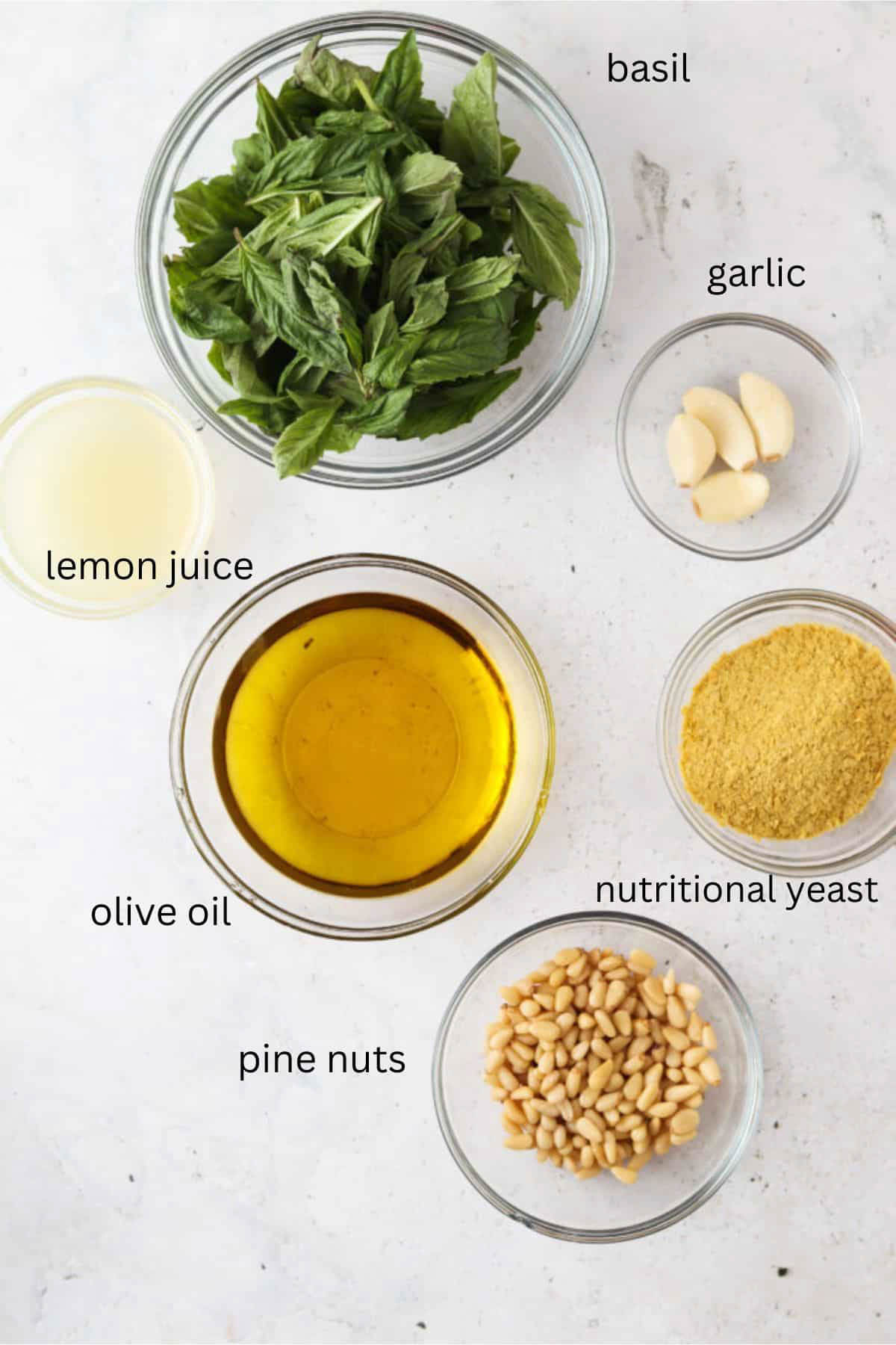 Whole30 pesto ingredients in small glass bowls.