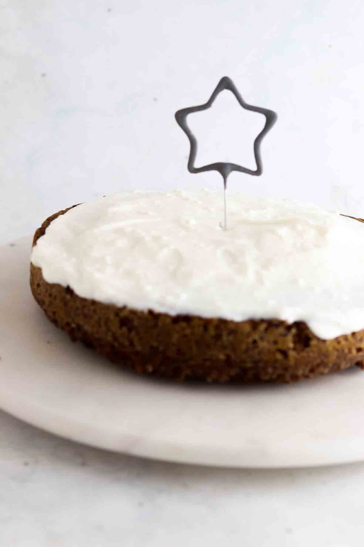 Dog cake on a cake stand with a star candle on top.