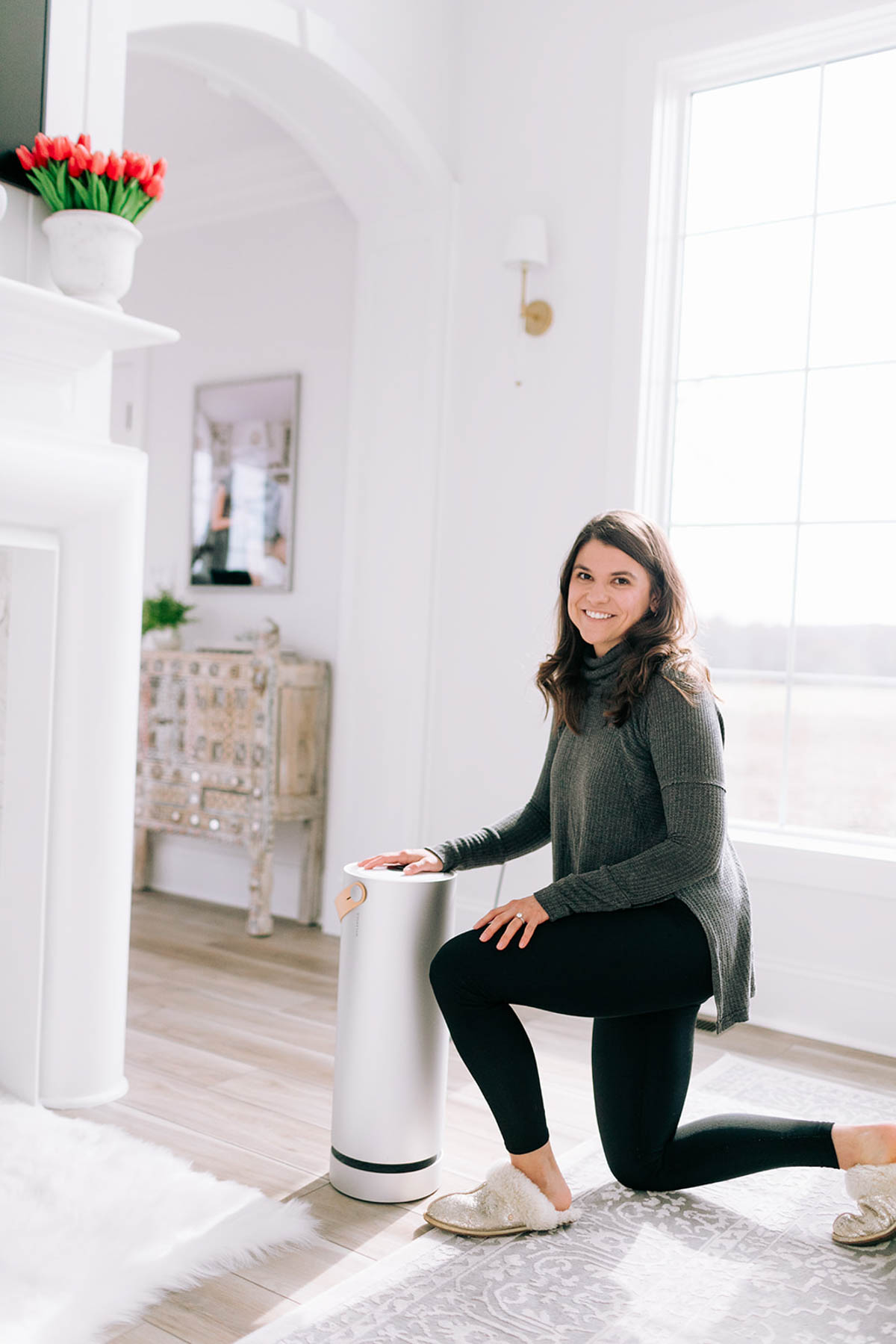 Allianna Moximchalk kneeling next to an air filter. 