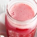 A mason jar with red syrup inside.