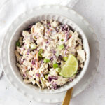 Gluten free coleslaw in a bowl with a gold spoon.