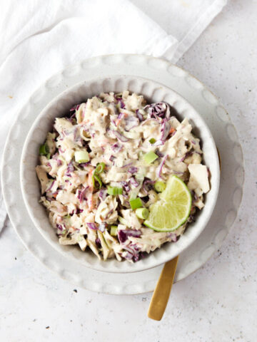 Gluten free coleslaw in a bowl with a gold spoon.