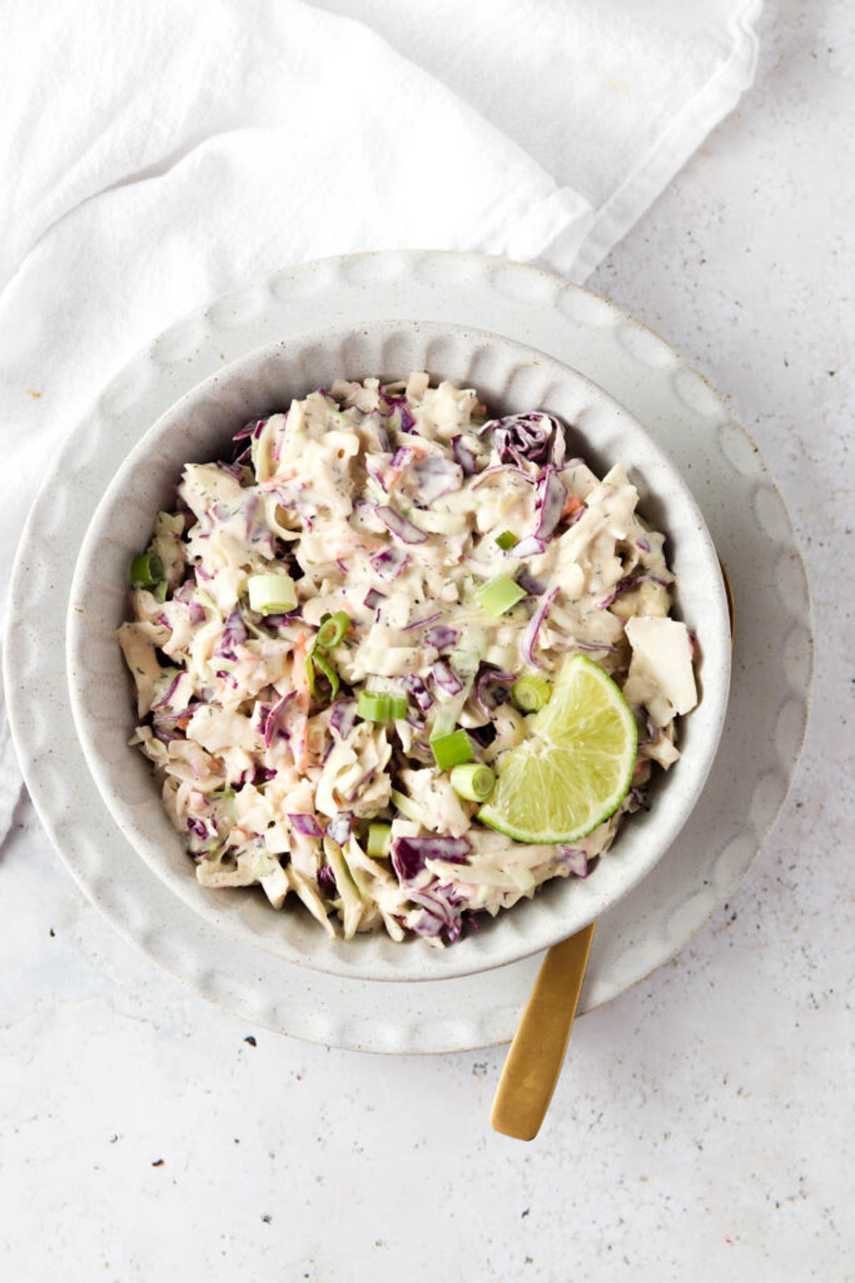 Whole30 gluten free coleslaw in a bowl with a spoon.