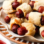 Gluten free pigs in a blanket in a pile on a plate.
