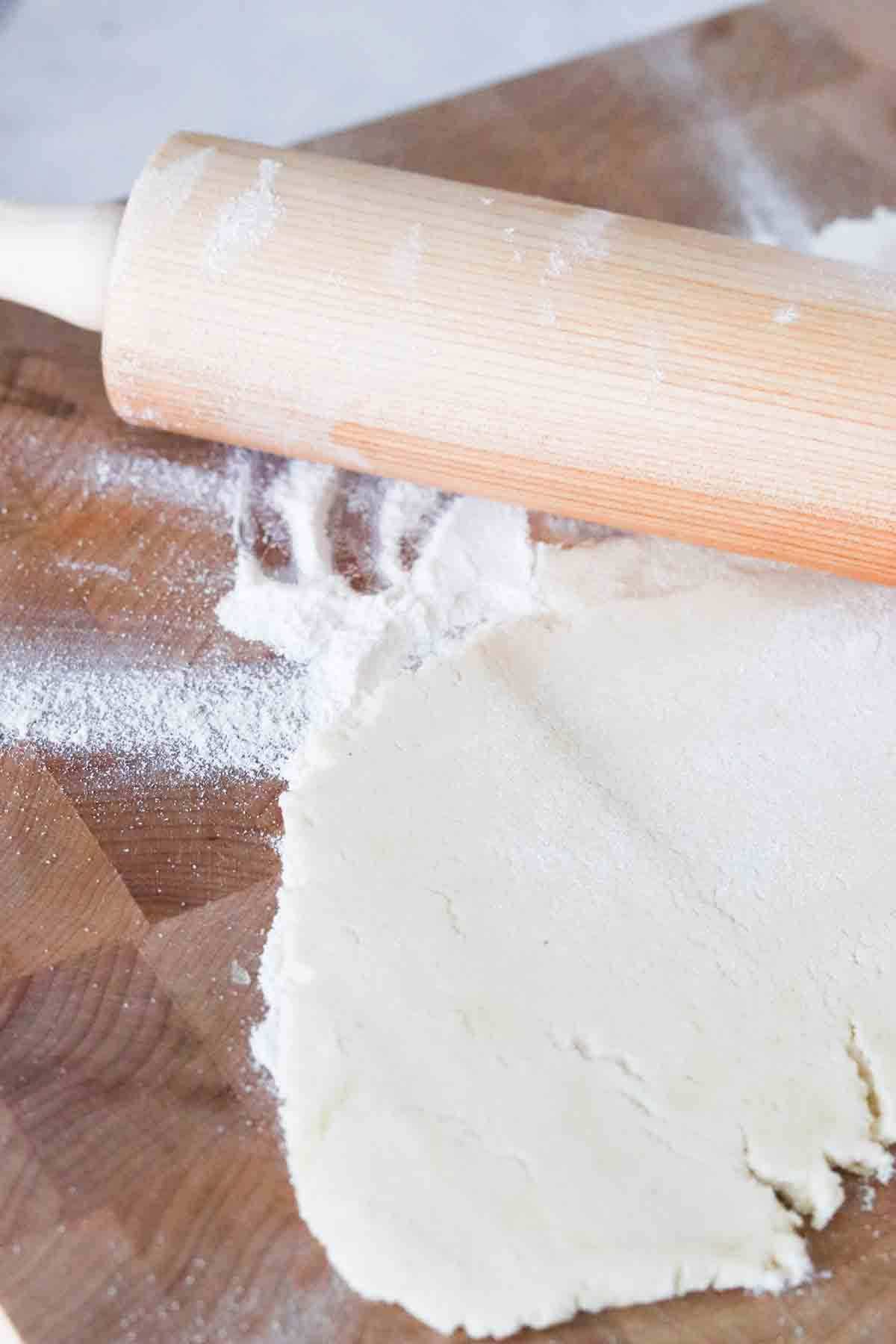Gluten free dough rolled out on a cutting board.