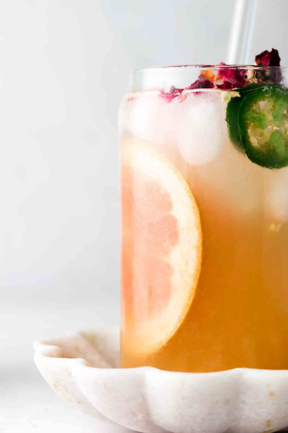 Grapefruit juice in a glass with a jalapeno on top.