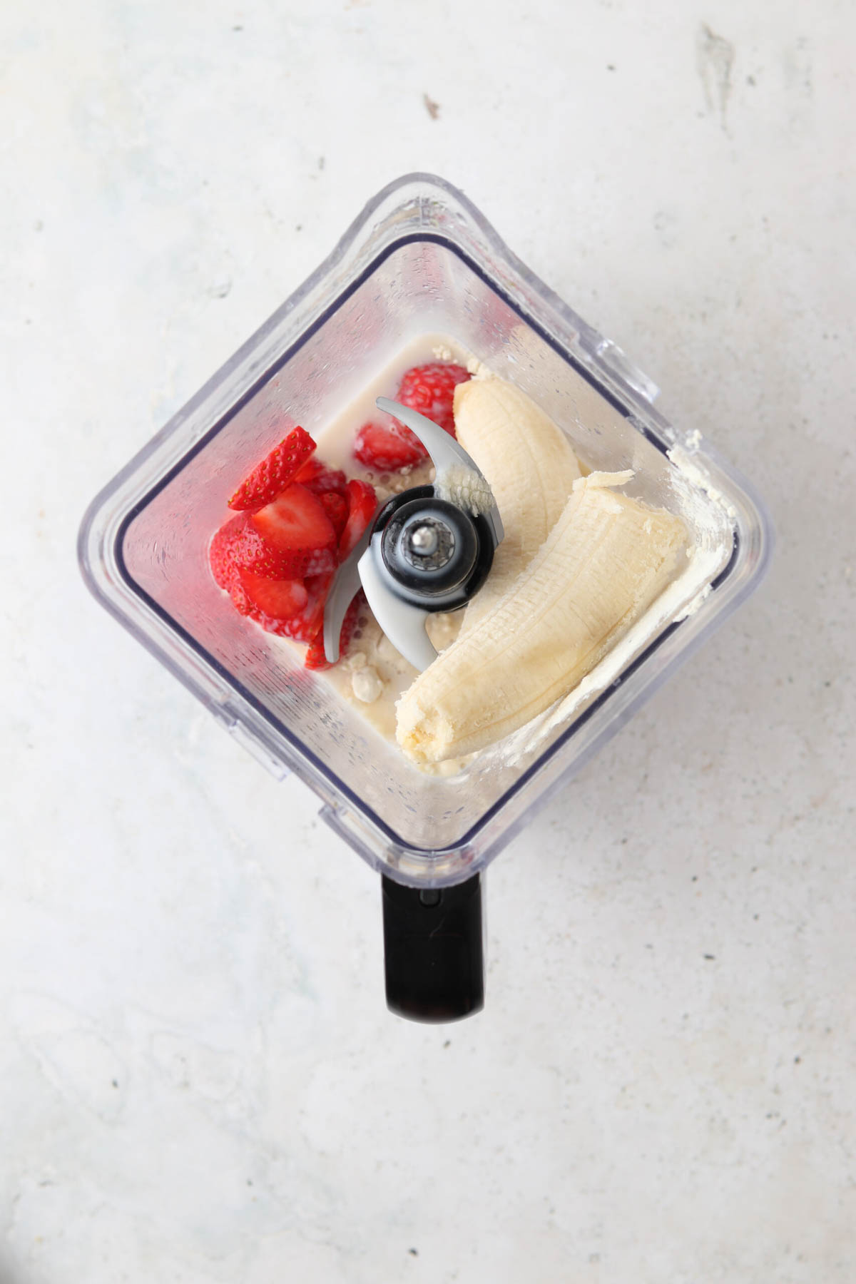 Strawberries, mango and banana in a food processor. 