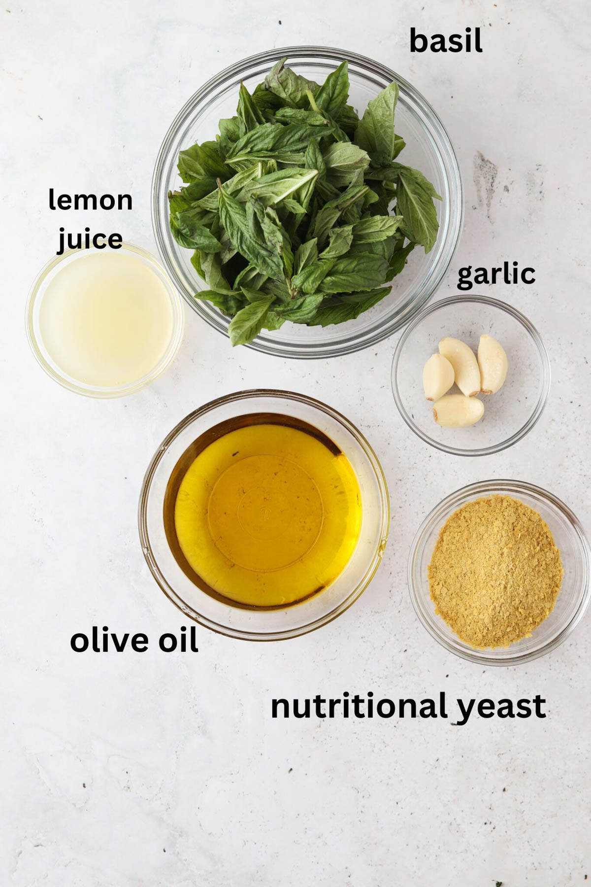 Nut free pesto ingredients in small glass bowls.