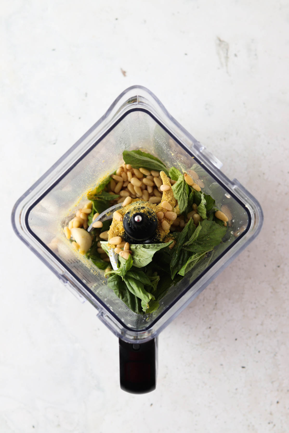 Pesto ingredients in a food processor. 