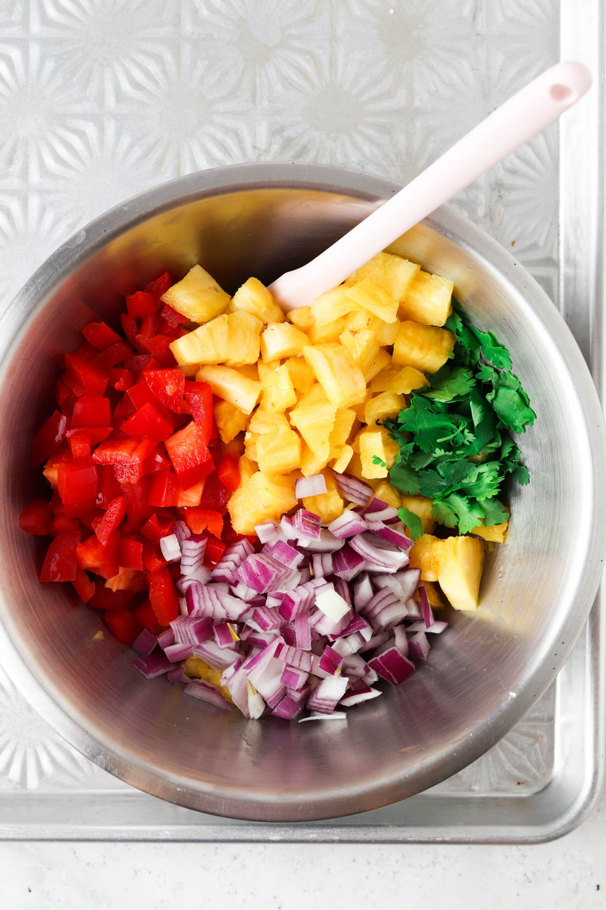 Pineapple pico de gallo ingredients in a mixing bowl. 