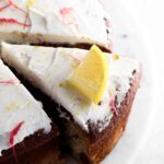 Cake with white frosting and a slice cut out of it.