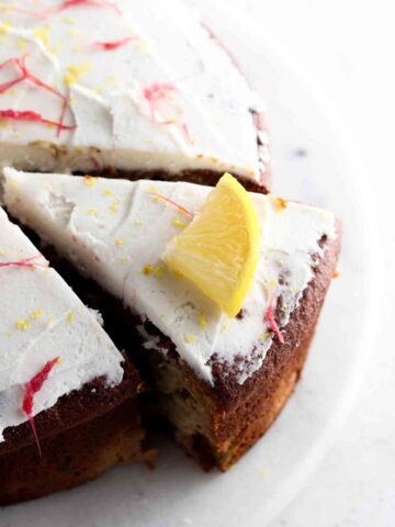Cake with white frosting and a slice cut out of it.