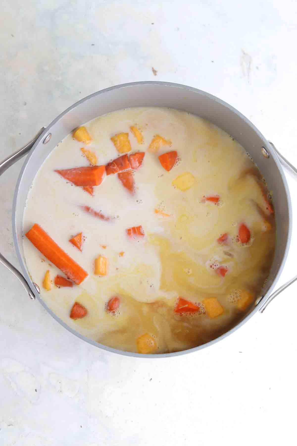 Butternut squash and carrot soup on the stove top.