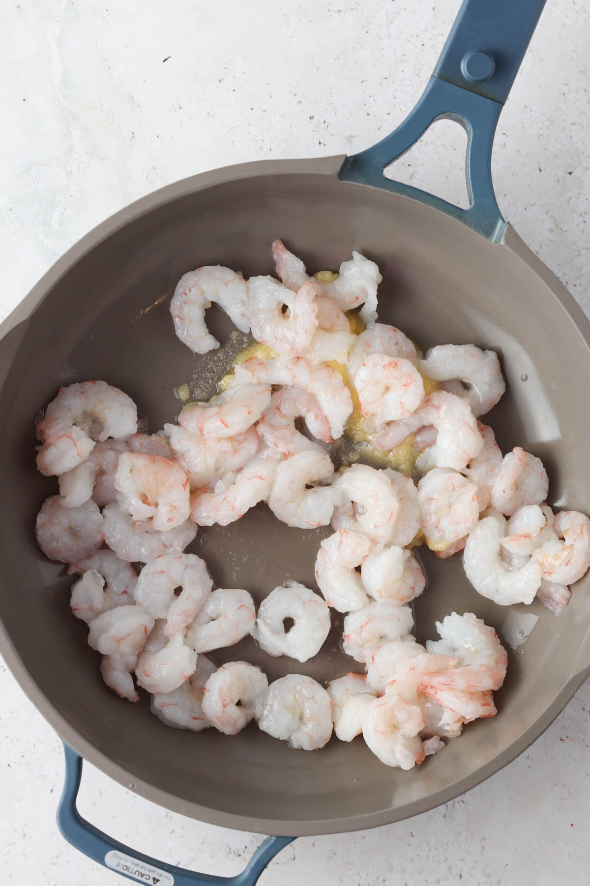 Shrimp cooked in a skillet with ghee.