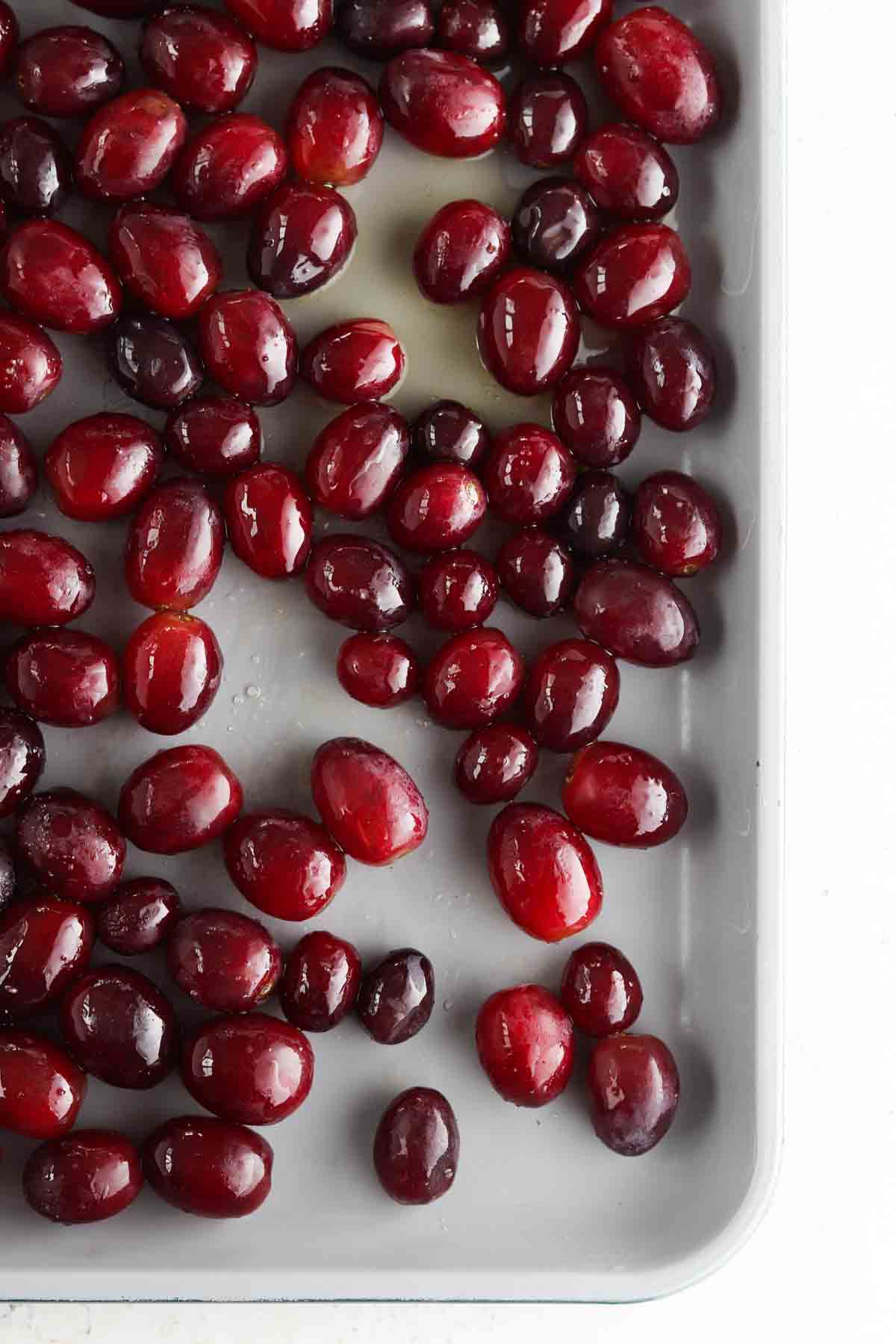 Grapes on a baking sheet with avocado oil and sea salt.