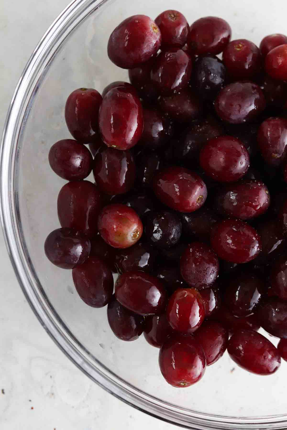 Grapes, avocado oil and sea salt in a glass bowl.