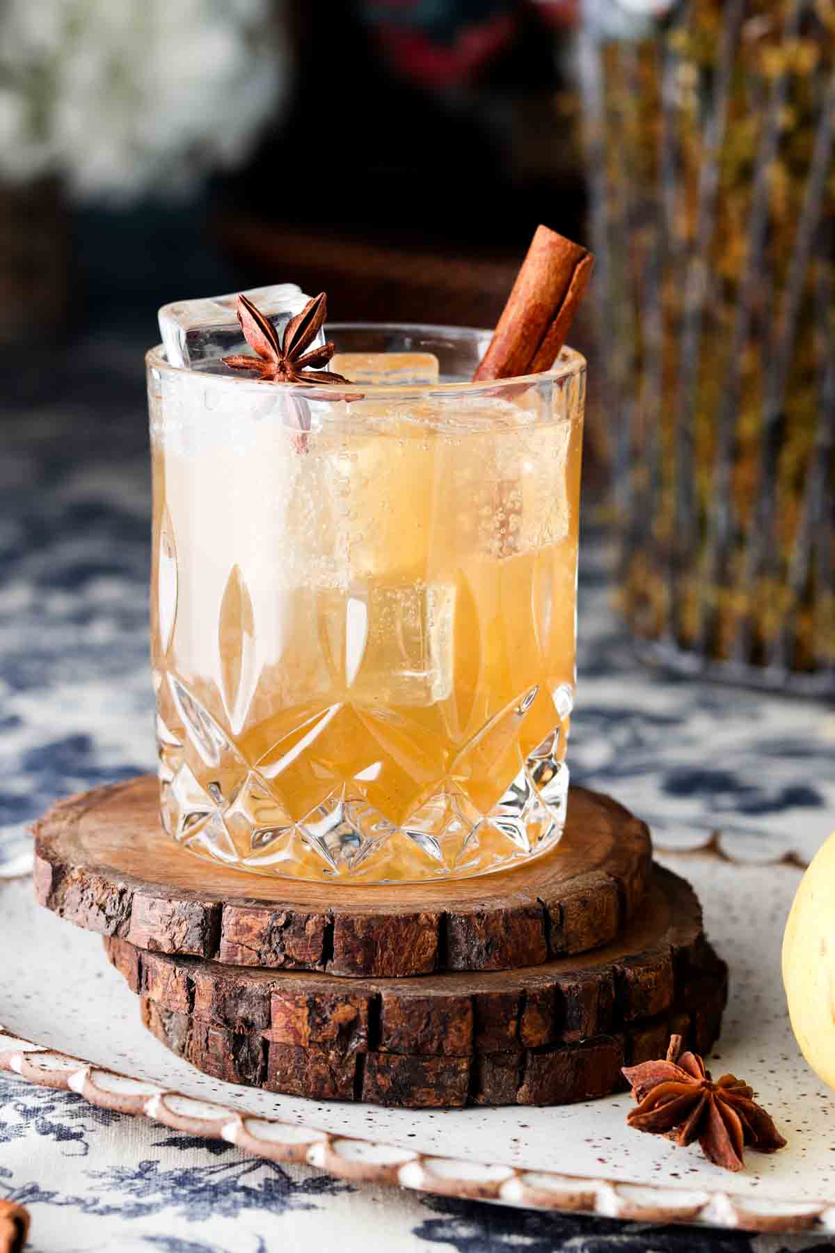 Clear glass with a brown drink and a cinnamon stick in it.