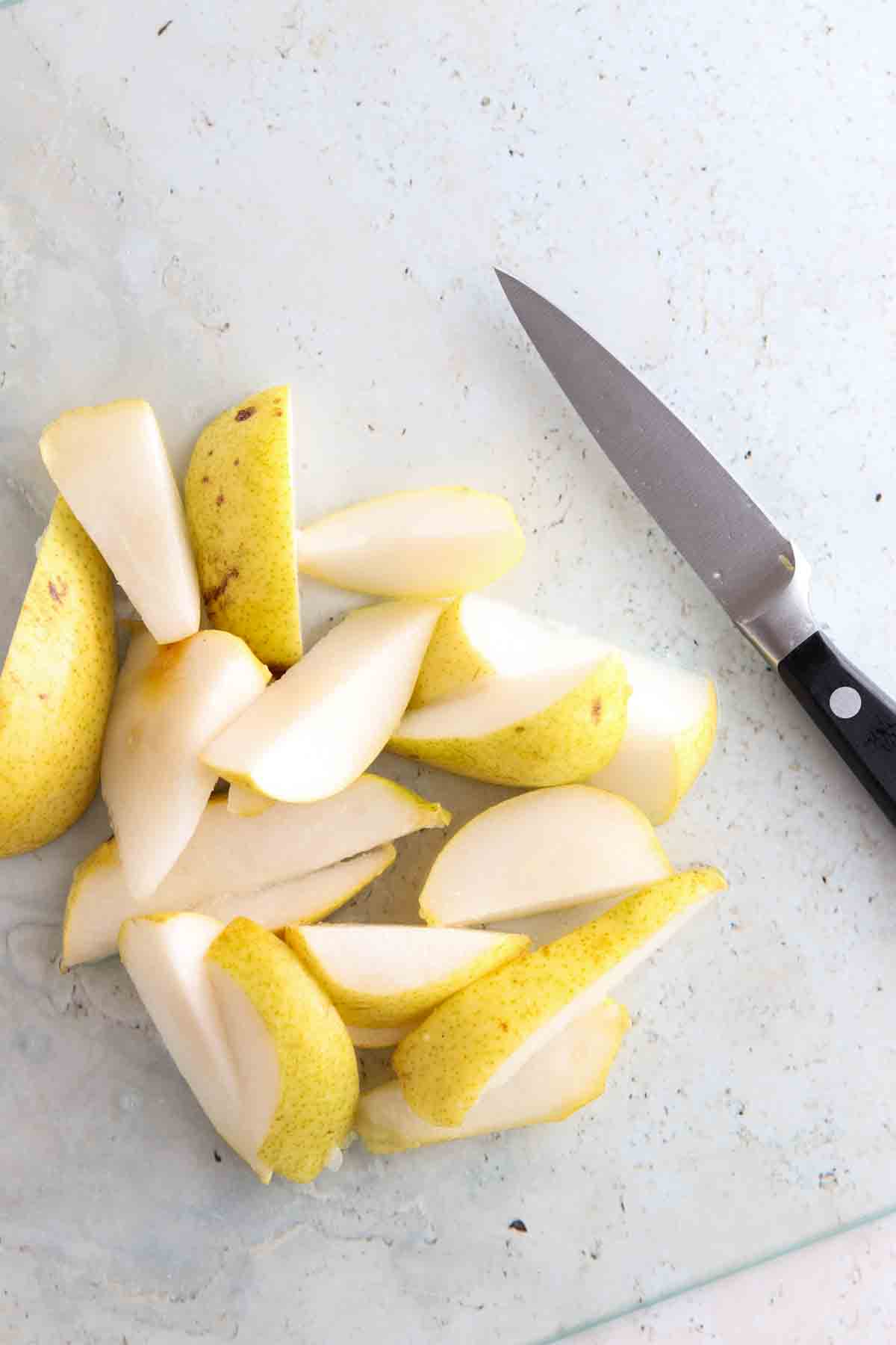 Pears on a cutting board with a knife. 