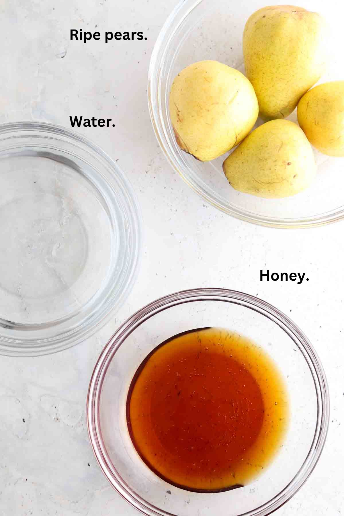 Pears, water and honey sitting on the counter.