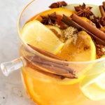 Lemons, apples, oranges, and cinnamon in a pot.