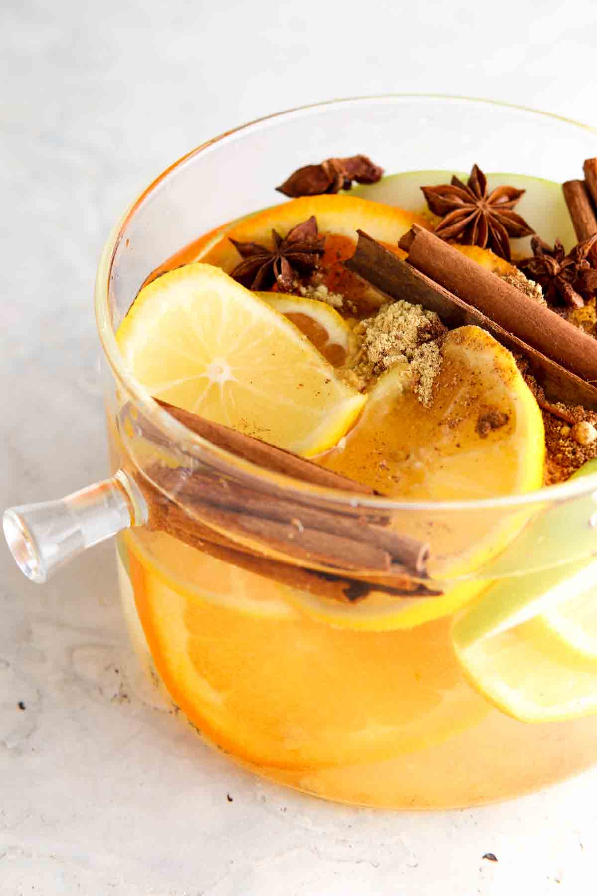 Lemons, apples, oranges, and cinnamon in a pot.