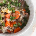 Italian wedding soup in a bowl with fresh parsley sprinkled on top.