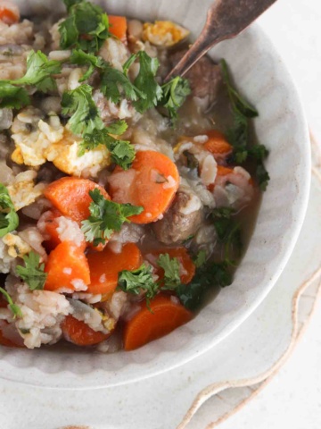 Italian wedding soup in a bowl with fresh parsley sprinkled on top.