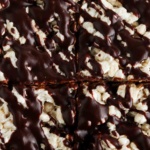 Rice crispy treats with chocolate drizzled on top.