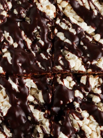 Rice crispy treats with chocolate drizzled on top.