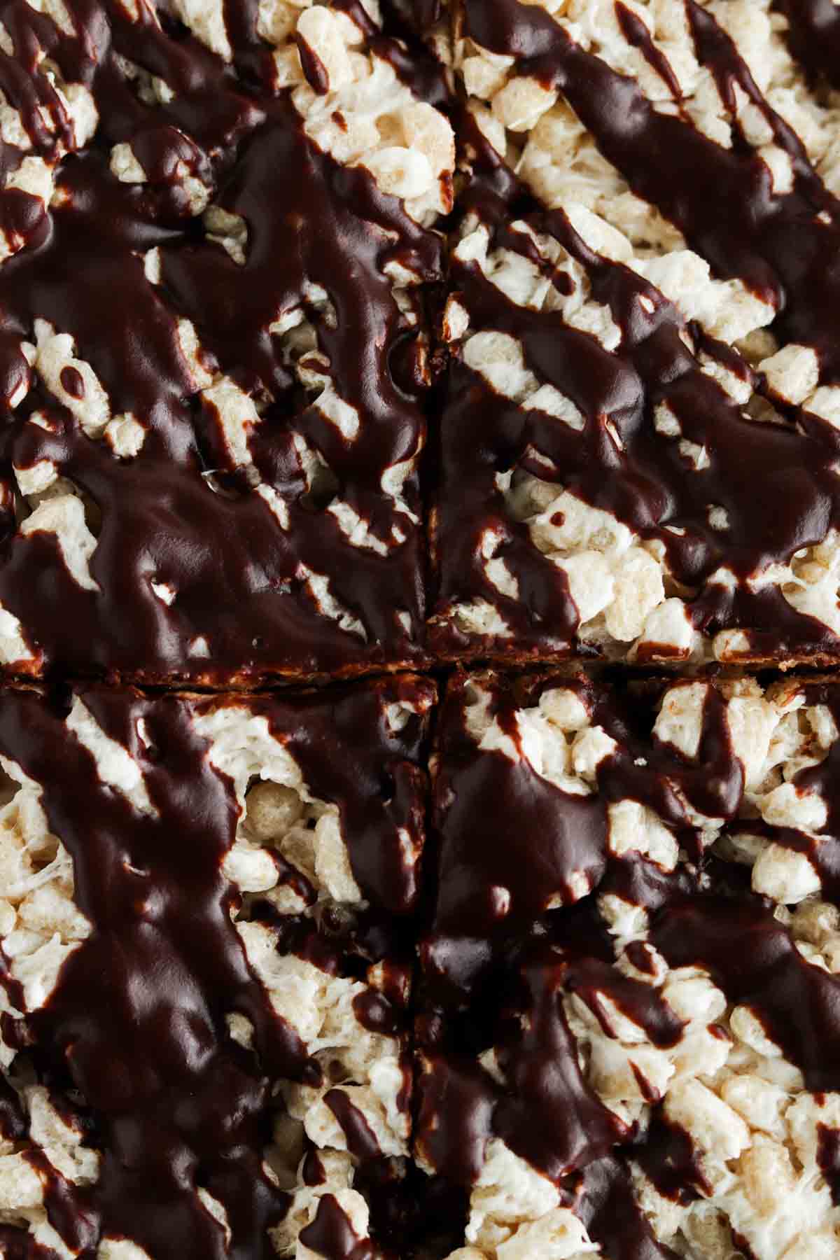 Rice crispy treats with chocolate drizzled on top.