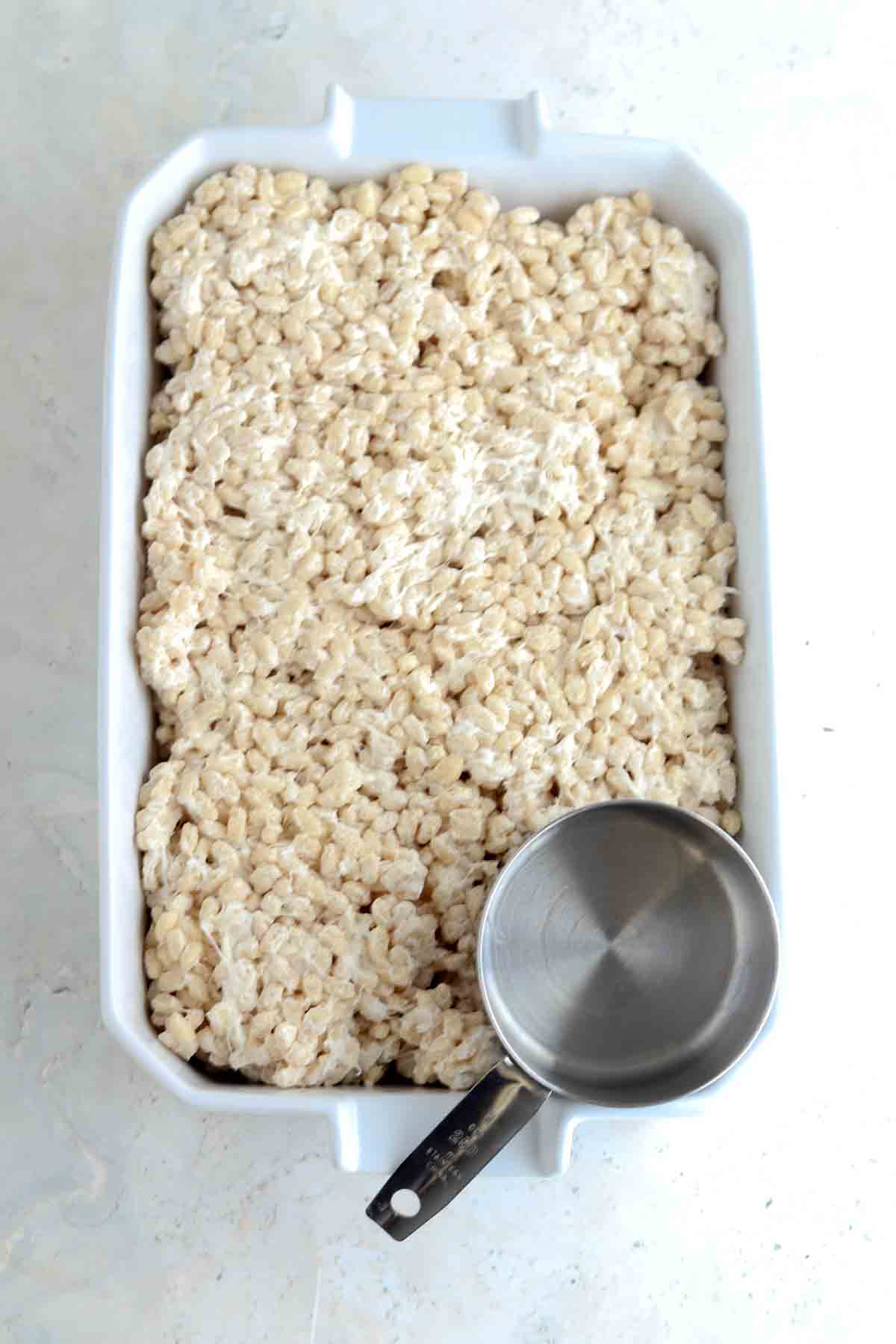 Rice crispies in a large baking pan leveled out.