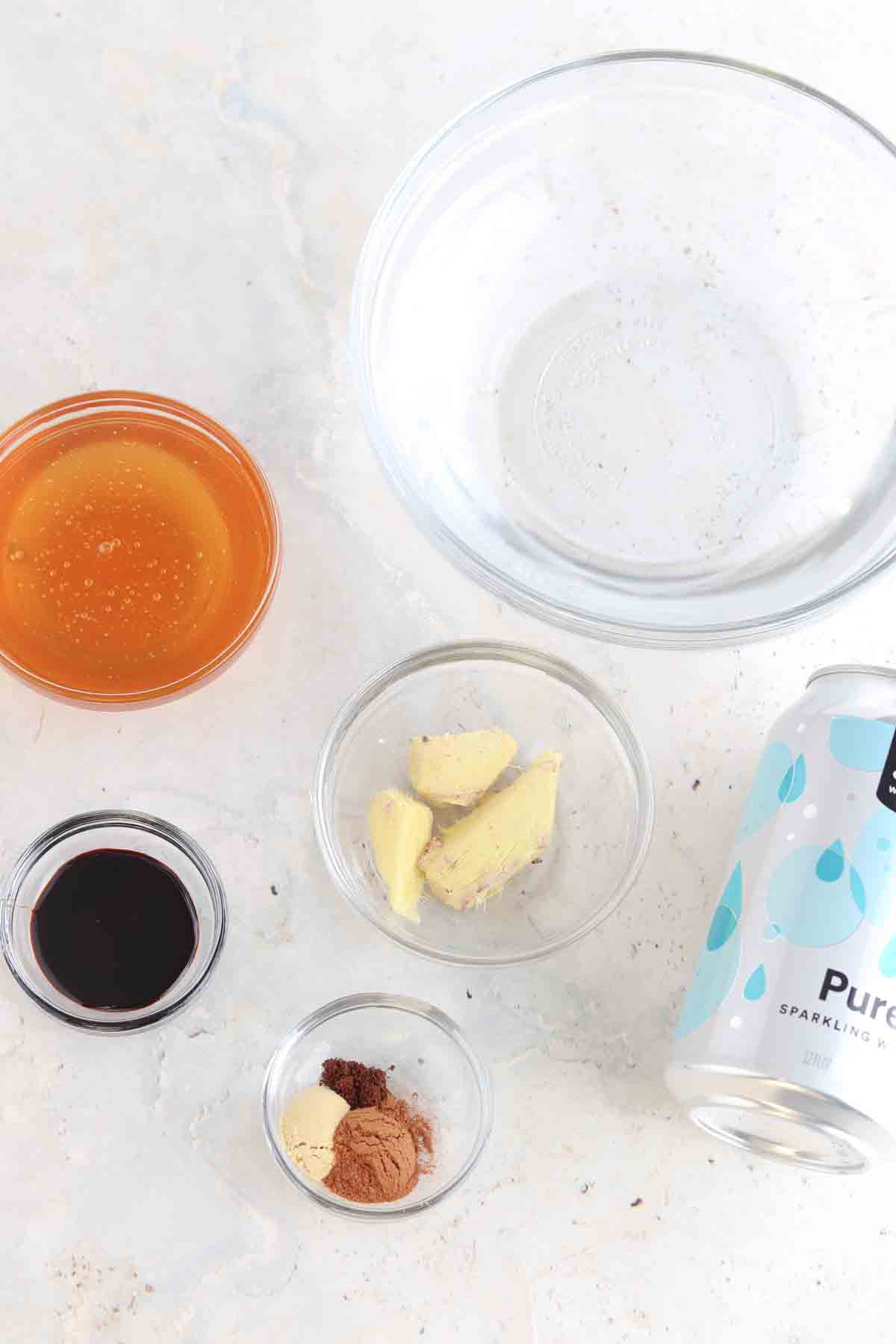 All ingredients on the counter laid out for the cocktail in small glass containers. 