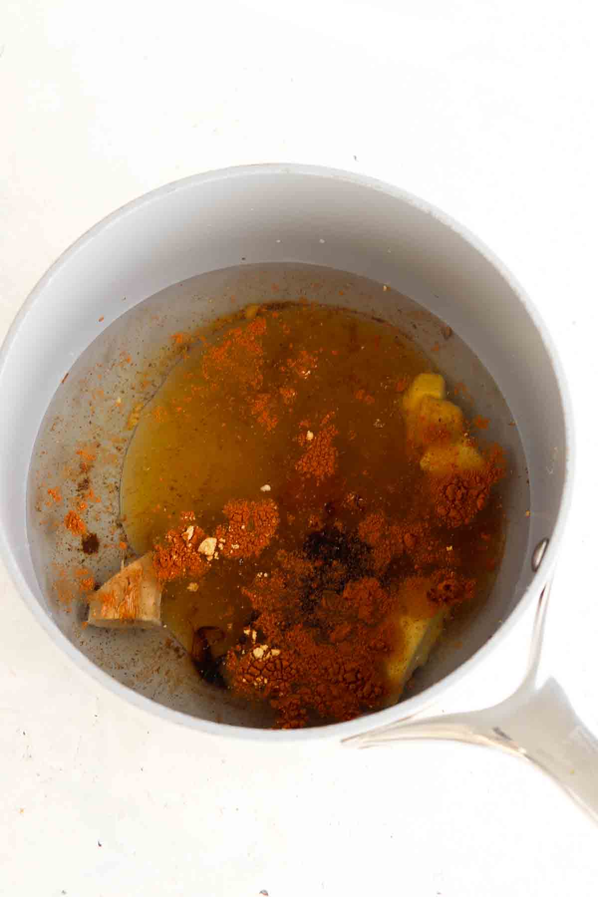 Small sauce pan of all of the ingredients for the simple syrup in the pot.
