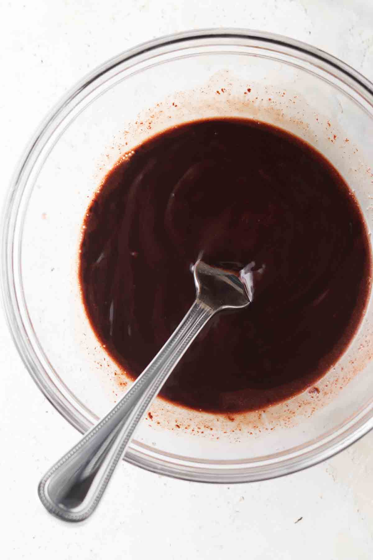 Whisked together chocolate and milk in a bowl with a fork. 