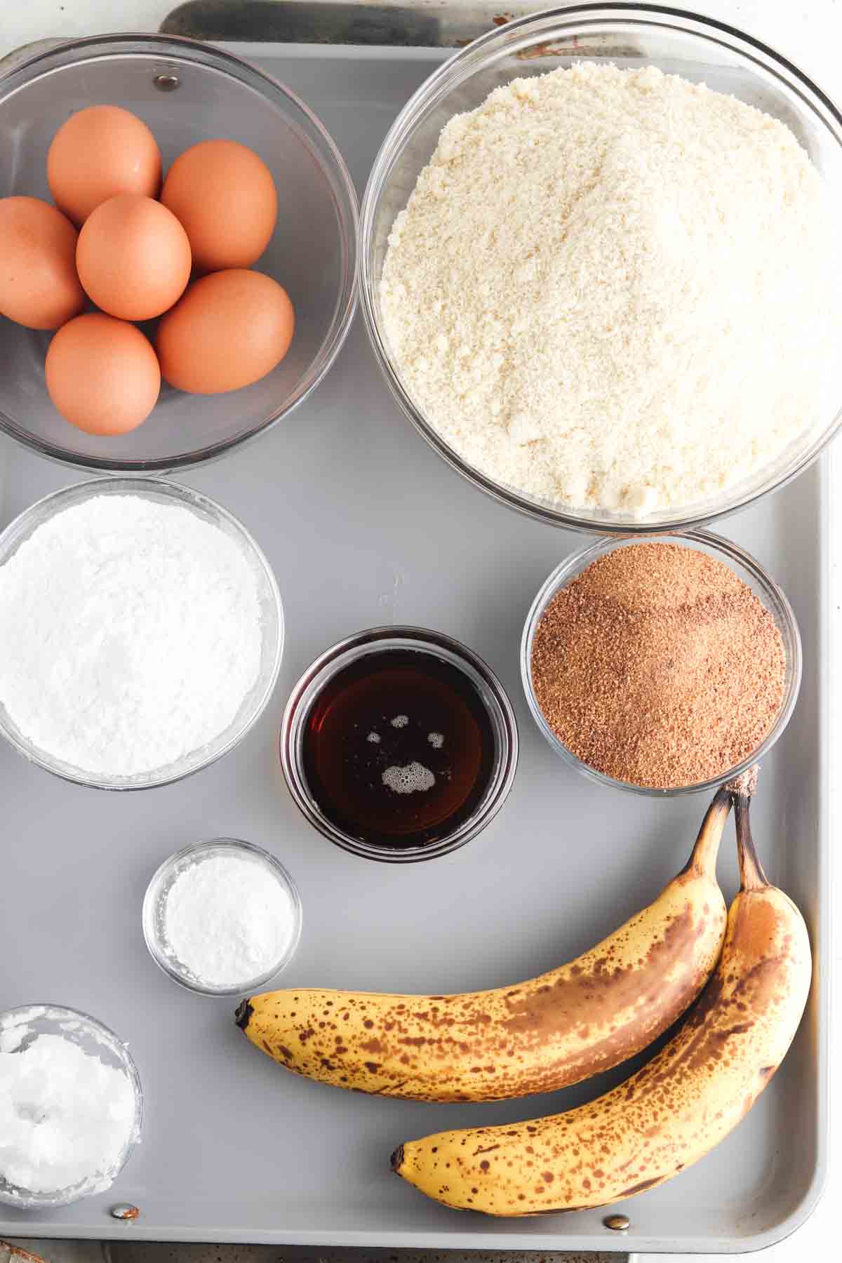 Cake ingredients laid out in small glass bowls. 