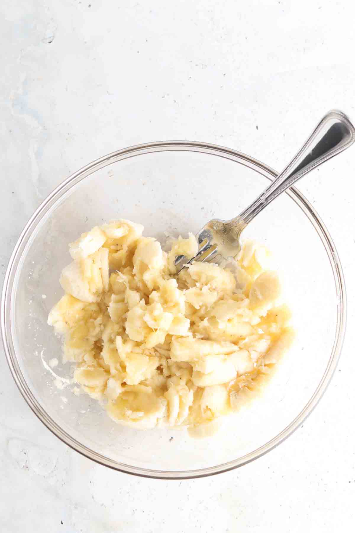 Banana bread wet ingredients mixed in a glass bowl. 