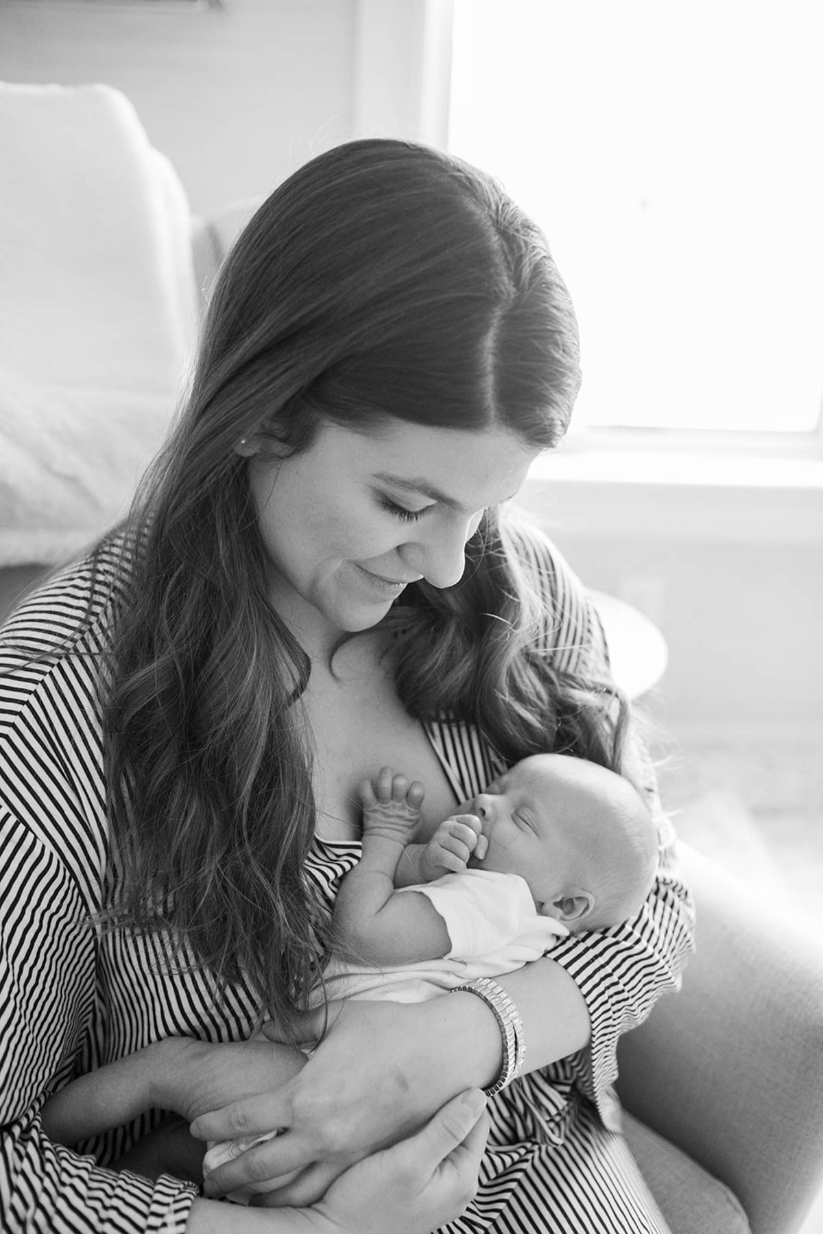 Allianna holding Brooks near a window.