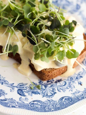 Egg salad on toasted bread with fresh microgreens on top.