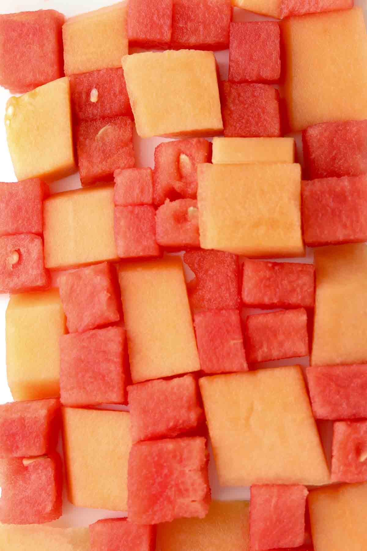 Lined up cantaloupe and watermelon on a platter. 